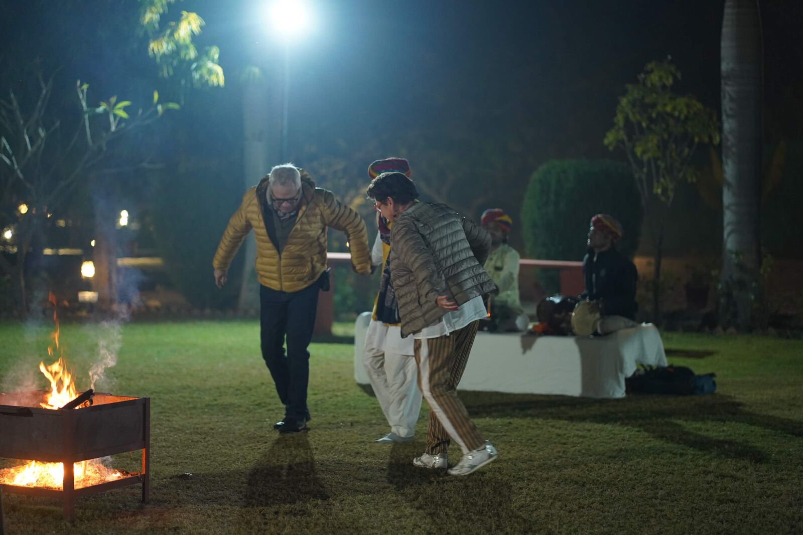 Guests dancing with folk musicians by a campfire