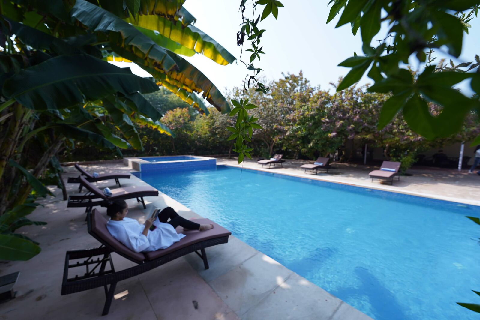 Guest reading on a lounger beside the pool