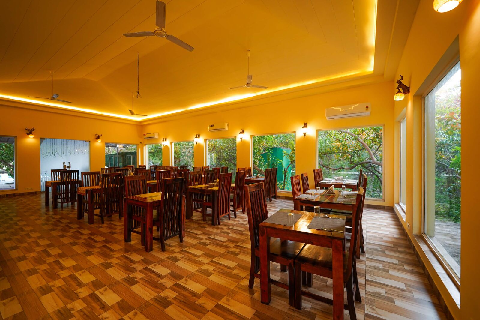 Sunlit resort dining room surrounded by trees