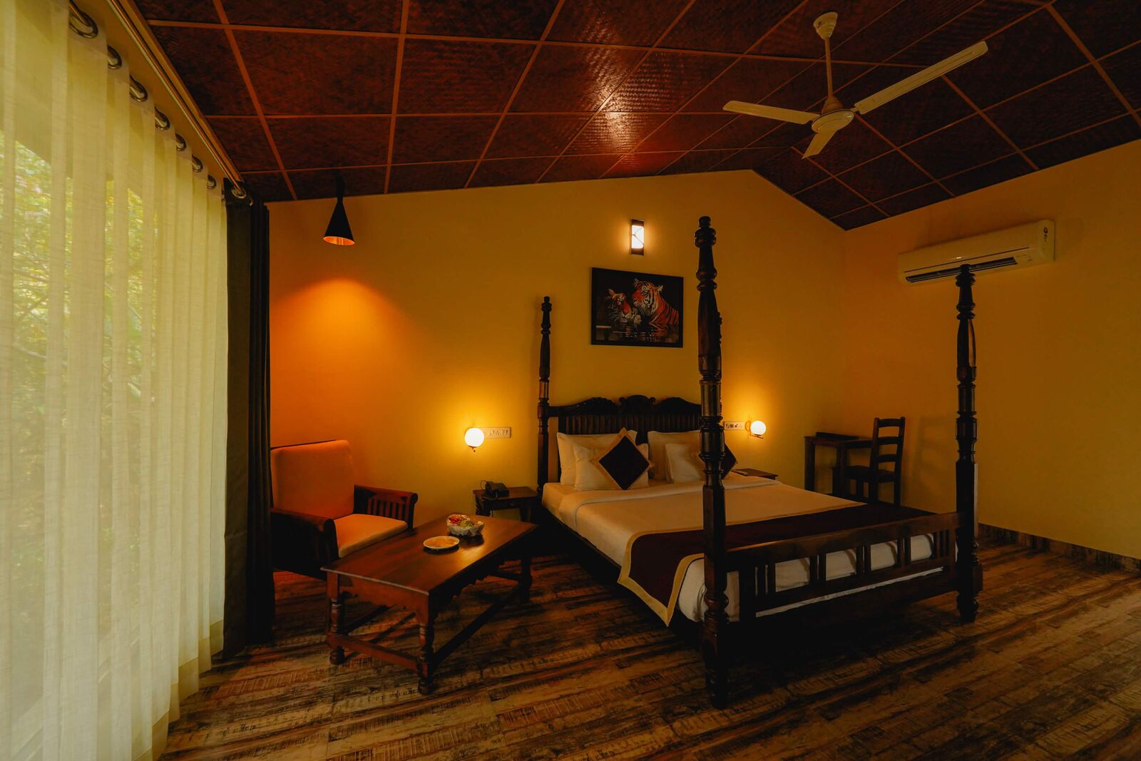 Four-poster resort room beside full-height curtains