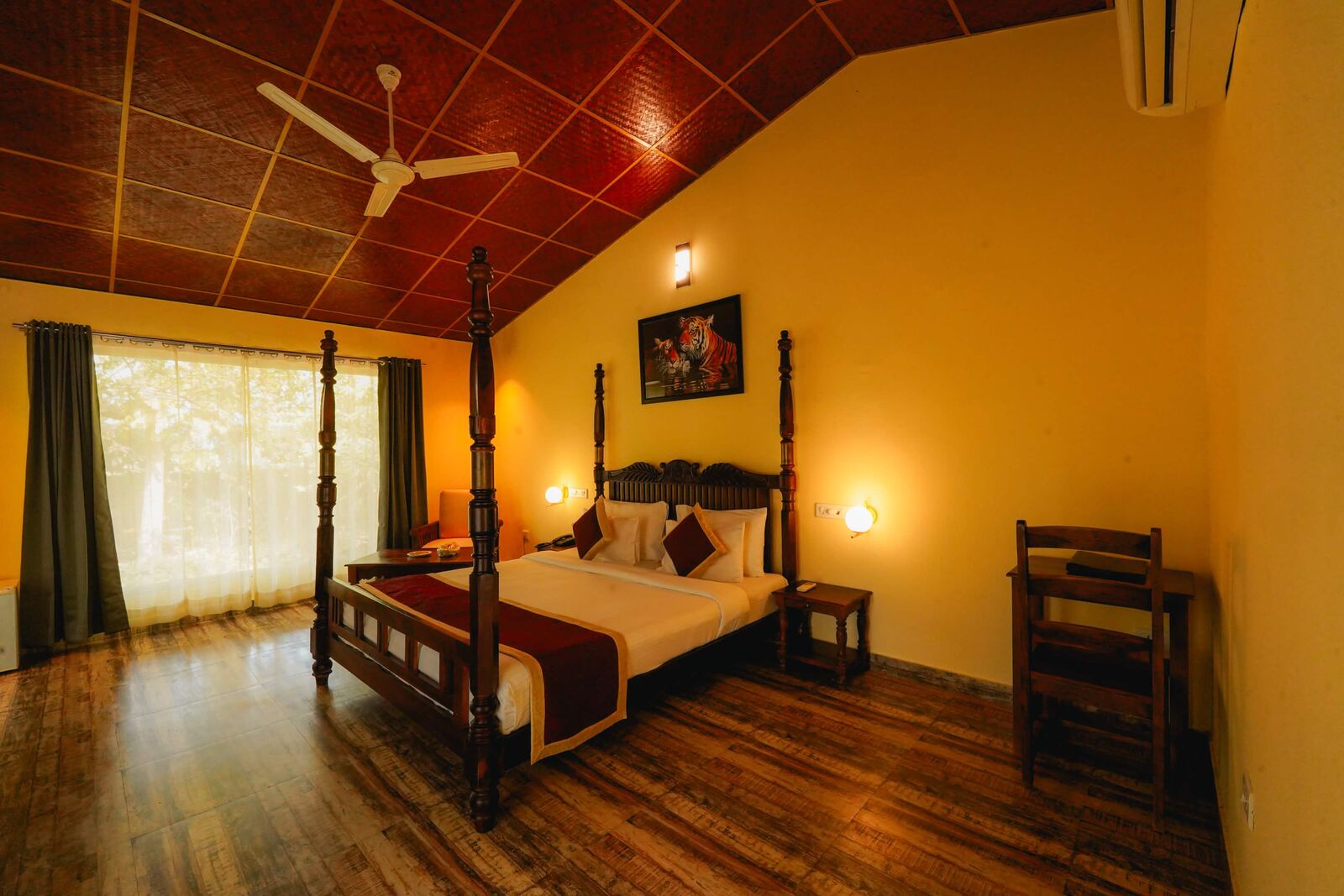 Four-poster resort room with garden-facing windows