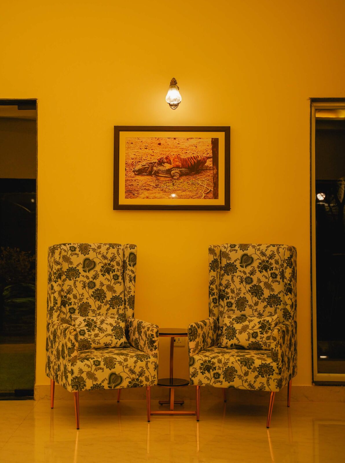 Floral lounge chairs beneath framed wildlife art