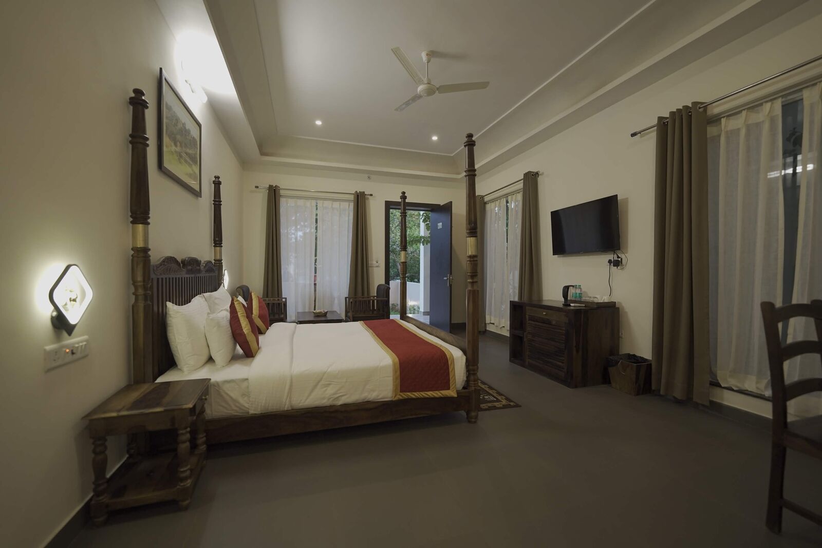 Four-poster resort room opening onto a terrace