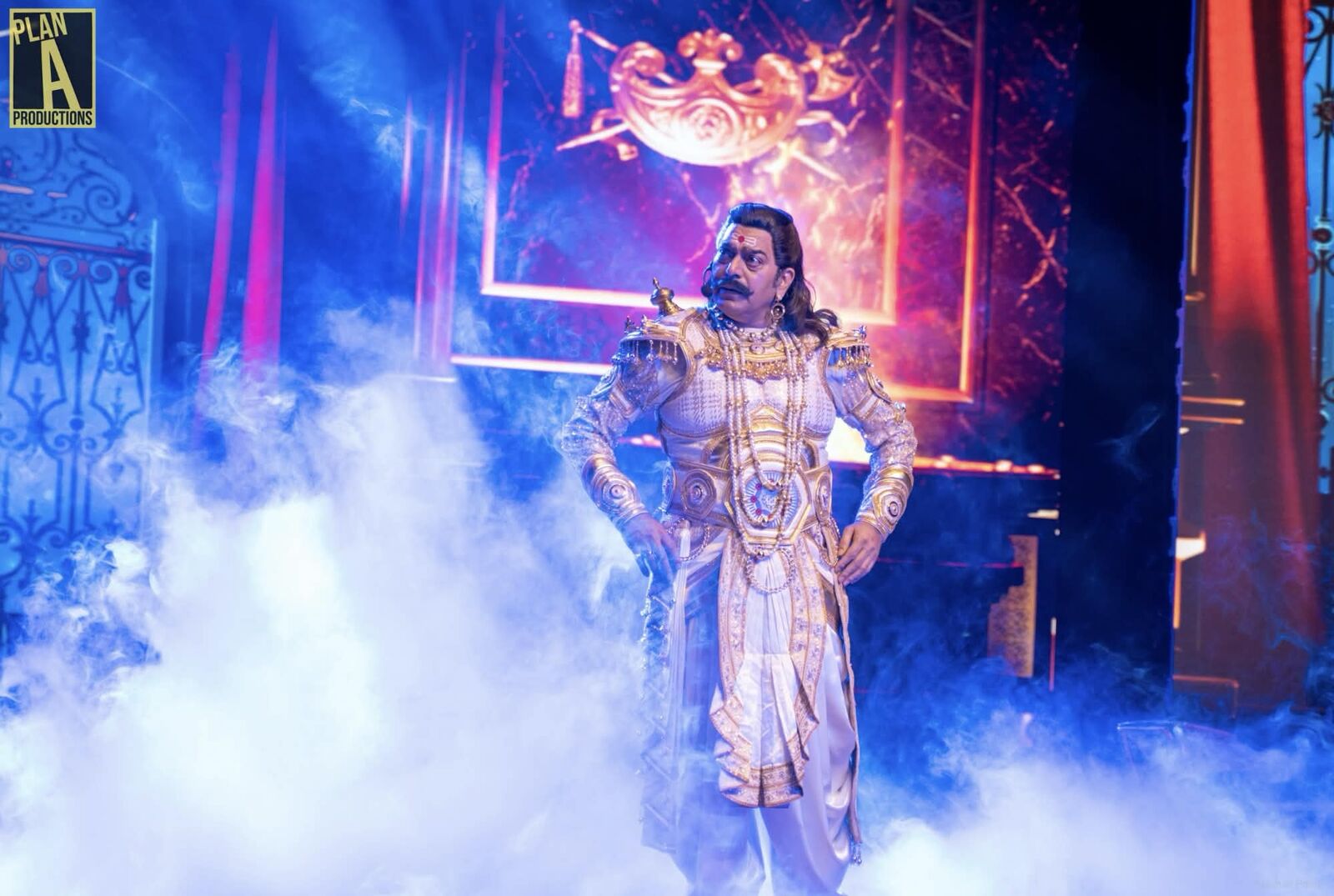 Silver-costumed performer on a smoke-filled stage